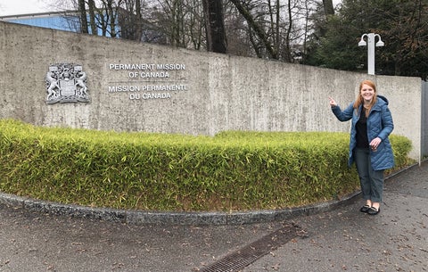 Kirsten Mosley pointing to a sign that says Permanent Mission of Canada at the United Nations