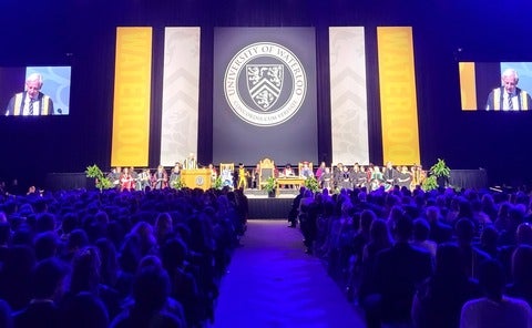 The convocation stage showing white and yellow banners and the Waterloo crest