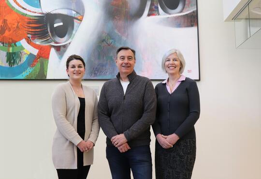 CORE steering committee members stand in front of an eye mural
